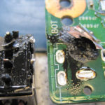 Durchgebrannte Strombuchse und beschädigte Durchkontaktierung am Mainboard.