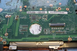 Das Mainboard des ASUS mit dem wieder aufgelöteten Steckverbinder. Unten zu sehen: Eine der beiden Festplatten.