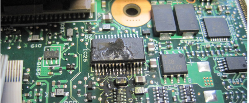Das beschädigte IC im Panasonic CF 19. Man sieht deutlich die Zerstörung durch die Überspannung. Die Bezeichnung war nur noch in Teilen lesbar