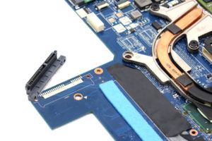 Die defekte SATA-Anschlussbuchse ist bereits entlötet und das Ersatzteil liegt bereit um mit dem Mainboard verschraubt und verlötet zu werden. Schön zu sehen auch das Schaumstoffteil zum späteren Schutz der Festplatte.