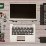 Zerlegtes Notebook. Display-Einheit, Topcase mit Tastatur, Mainboard, Festplatte, Lüfter, Netzteil.