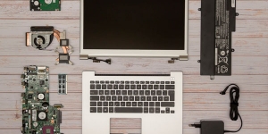 Zerlegtes Notebook. Display-Einheit, Topcase mit Tastatur, Mainboard, Festplatte, Lüfter, Netzteil.